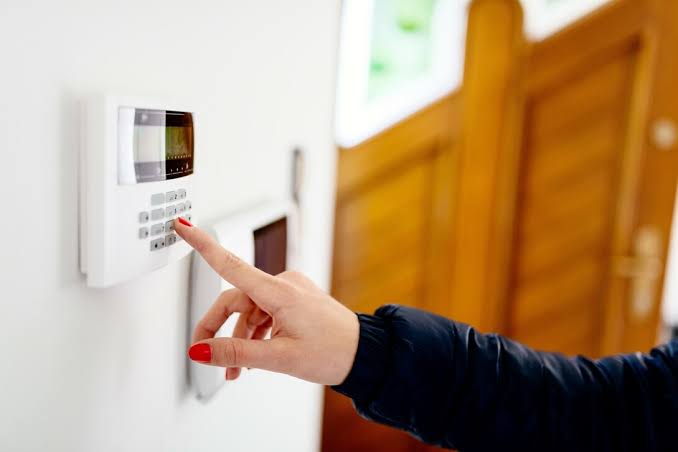 Homeowner arming an alarm system using a wall-mounted keypad